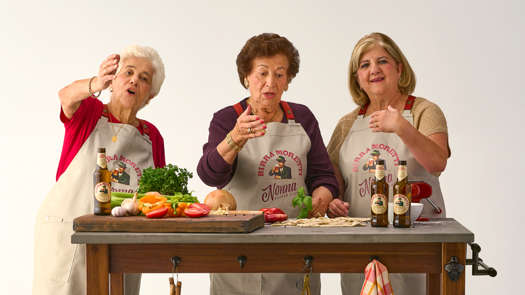Italian nonnas passing on their culinary expertise around a table filled with cooking ingredients.